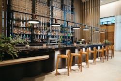 The back bar of steel and woven rope at 1 Kitchen lowers to secure the liquor bottles once the bar is closed. The back bar of steel and woven rope at 1 Kitchen lowers to secure the liquor bottles once the bar is closed.
