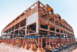 To prepare for lifting Building 12, temporary bracing beams were installed at the first-floor level and at the roof, the monitor window glass was removed and new roof sheathing installed to make the building rigid enough to prevent it from racking during the lift. To prepare for lifting Building 12, temporary bracing beams were installed at the first-floor level and at the roof, the monitor window glass was removed and new roof sheathing installed to make the building rigid enough to prevent it from racking during the lift.