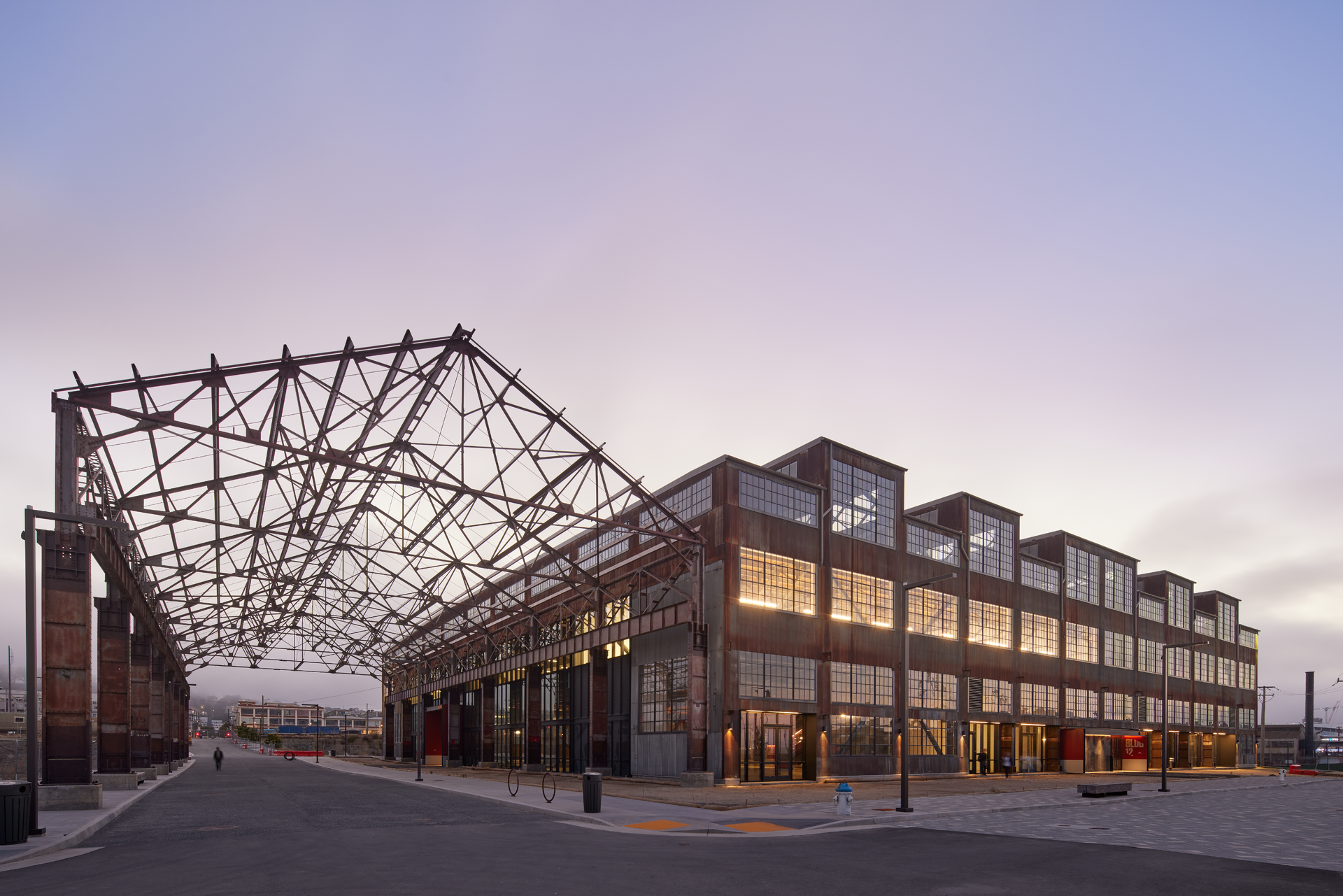 The 230,000-square-foot facility welcomes visitors to the grand market hall via three colossal, red portals and fully operable window walls along key facades to provide maximum porosity between the interior market hall and the surrounding pedestrian plazas and streets.