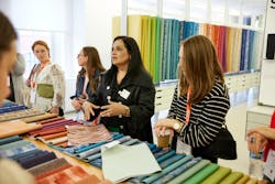 Visitors to this NeoCon showroom examine textiles. The 2023 show embodied its theme, “Together We Design.” Visitors to this NeoCon showroom examine textiles. The 2023 show embodied its theme, “Together We Design.”