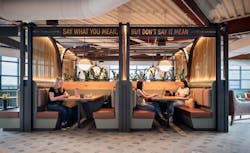 The train cabooses highlight the nearby railroad in the space, known as the rail yards. The top sign is illuminated with warm light, with each caboose divided by copper mesh and lit with decorative pendants. The train cabooses highlight the nearby railroad in the space, known as the rail yards. The top sign is illuminated with warm light, with each caboose divided by copper mesh and lit with decorative pendants.