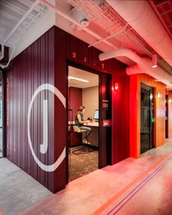 Phone rooms are designed to resemble shipping containers. Each room is wired with a tunable white lighting system along with an occupancy device to switch the exterior wall light from white to red.
