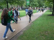 College students use a sidewalk to move through campus.