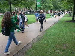 College students use a sidewalk to move through campus. College students use a sidewalk to move through campus.
