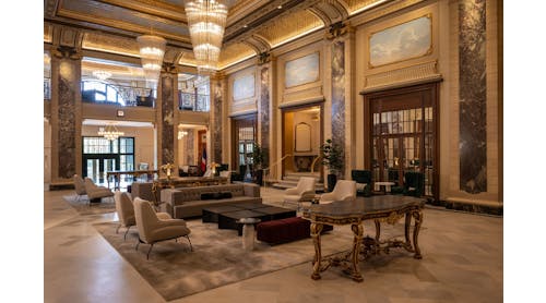 The Belden-Stratford&rsquo;s ornate double-height lobby features restored original elements such as gilded plaster molding and gold-leaf detailing.