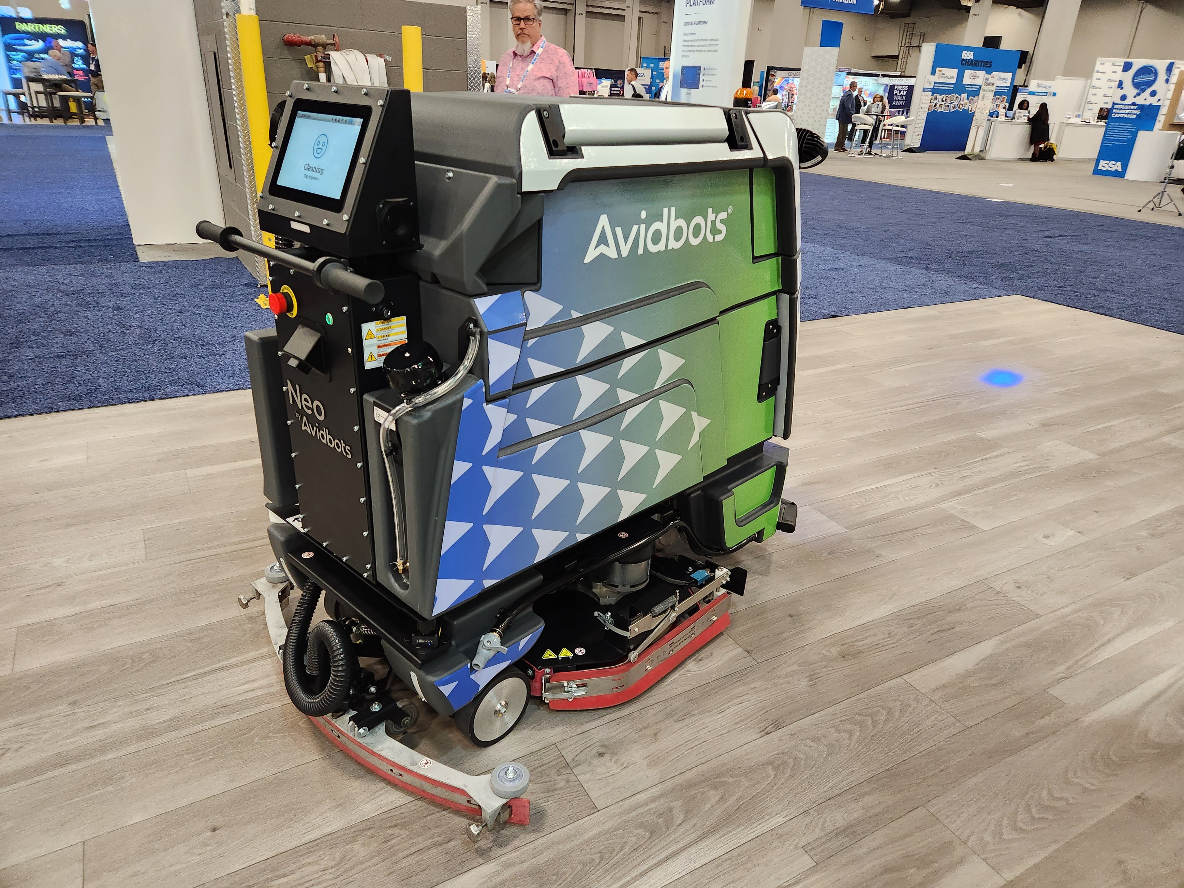 Neo 2, a floor scrubber by AvidBots, cleans the floor at the 2023 ISSA Show North America.