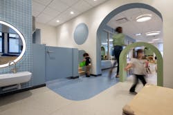 The classroom features a toddler-sized archway. This entrance is often the first time some children experience a threshold designed specifically for their height.