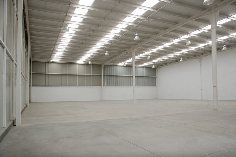 An empty industrial warehouse illuminated by solar light.