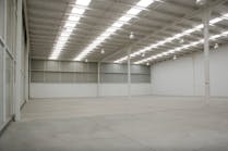 An empty industrial warehouse illuminated by solar light.