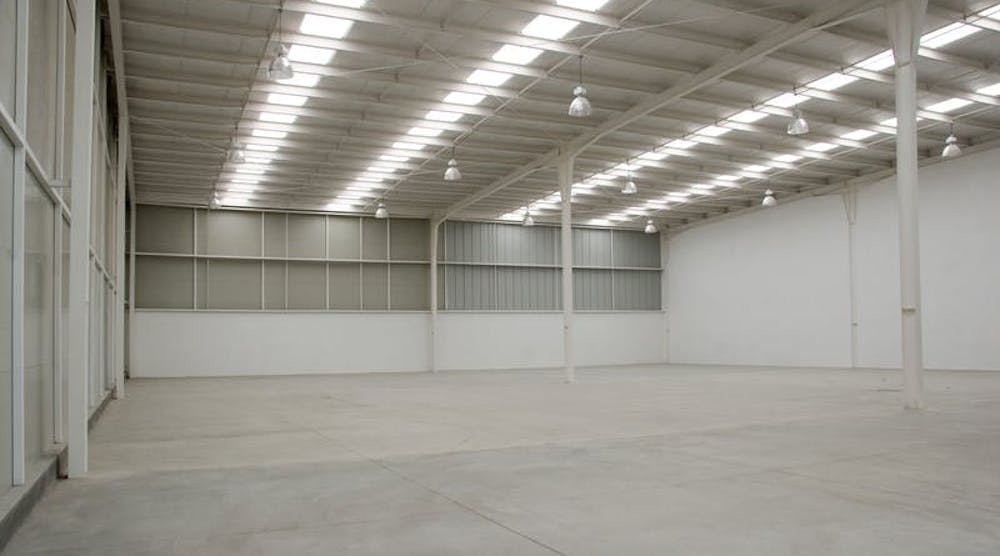 An empty industrial warehouse illuminated by solar light.