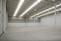 An empty industrial warehouse illuminated by solar light. An empty industrial warehouse illuminated by solar light.