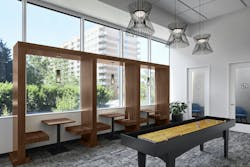 This gaming area at 2677 Prosperity Avenue in Fairfax, Virginia, features a shuffleboard table, built-in seating and some privacy rooms for phone calls. It replaced a private conference room that was rarely utilized. 2677 Prosperity Avenue recently underwent an amenity-focused renovation by GTM Architects.