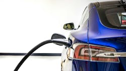 An electric vehicle charges at a charging station. An electric vehicle charges at a charging station.