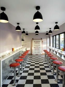 Interior of 50s-inspired diner with checkered floors and red bar stools. Interior of 50s-inspired diner with checkered floors and red bar stools.