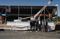 Edged employees attend the topping out event for the Columbus data center location. The topping out event occurred in October 2024, after four months of construction. They stand in front of the building and construction equipment. Edged employees attend the topping out event for the Columbus data center location. The topping out event occurred in October 2024, after four months of construction. They stand in front of the building and construction equipment.
