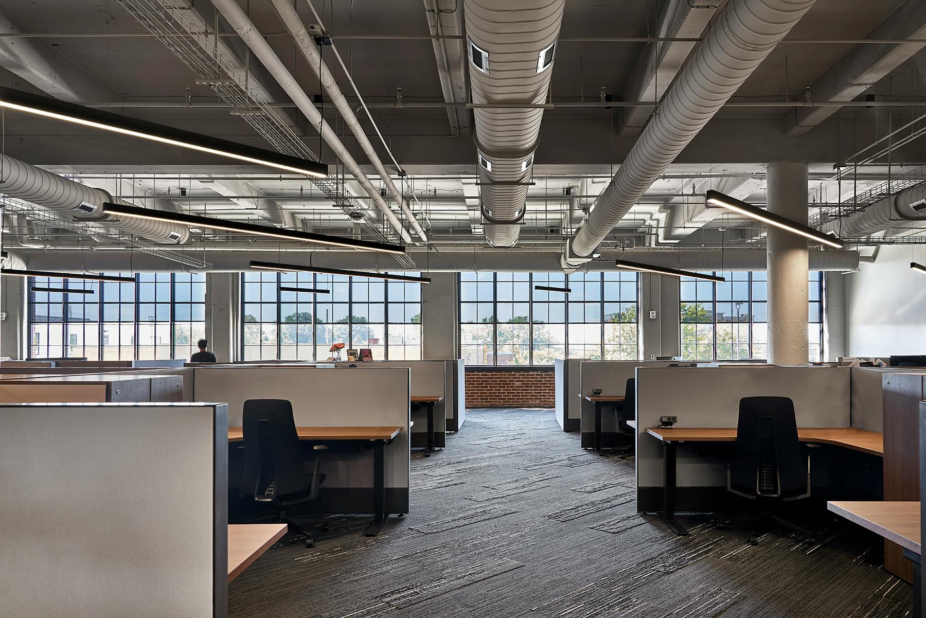 Memphis architectural design firm LRK worked with A-Light luminaires to enhance the natural light coming into the new Orion Federal Credit Union headquarters in a historic building that incorporates the original industrial-looking concrete and exposed ductwork alongside modern aesthetics and layered lighting. (Photo credits: Images by McGinn Photography for A-Light.)