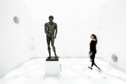FIG. 1. Planar lighting behind a textile surface delivers an almost dimensionless space where visitors see the Greek athlete Apoxyomenos risen from the seabed, presented with no shadows yet with lighting that reveals the architectural detail of the bronze work. (Photo credit: All photos, Zumtobel/photographer Faruk Pinjo.) FIG. 1. Planar lighting behind a textile surface delivers an almost dimensionless space where visitors see the Greek athlete Apoxyomenos risen from the seabed, presented with no shadows yet with lighting that reveals the architectural detail of the bronze work. (Photo credit: All photos, Zumtobel/photographer Faruk Pinjo.)