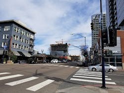 FIG. 1. San Diego is installing the Current CityIQ nodes on both cobrahead and decorative gaslamp-style poles with LED luminaires. The busy Market Street includes both types, and with two lanes of traffic in each direction and a turn lane, the sensor nodes with two-way cameras line both sides of the street. (Photo credits: All photos, Maury Wright.) FIG. 1. San Diego is installing the Current CityIQ nodes on both cobrahead and decorative gaslamp-style poles with LED luminaires. The busy Market Street includes both types, and with two lanes of traffic in each direction and a turn lane, the sensor nodes with two-way cameras line both sides of the street. (Photo credits: All photos, Maury Wright.)