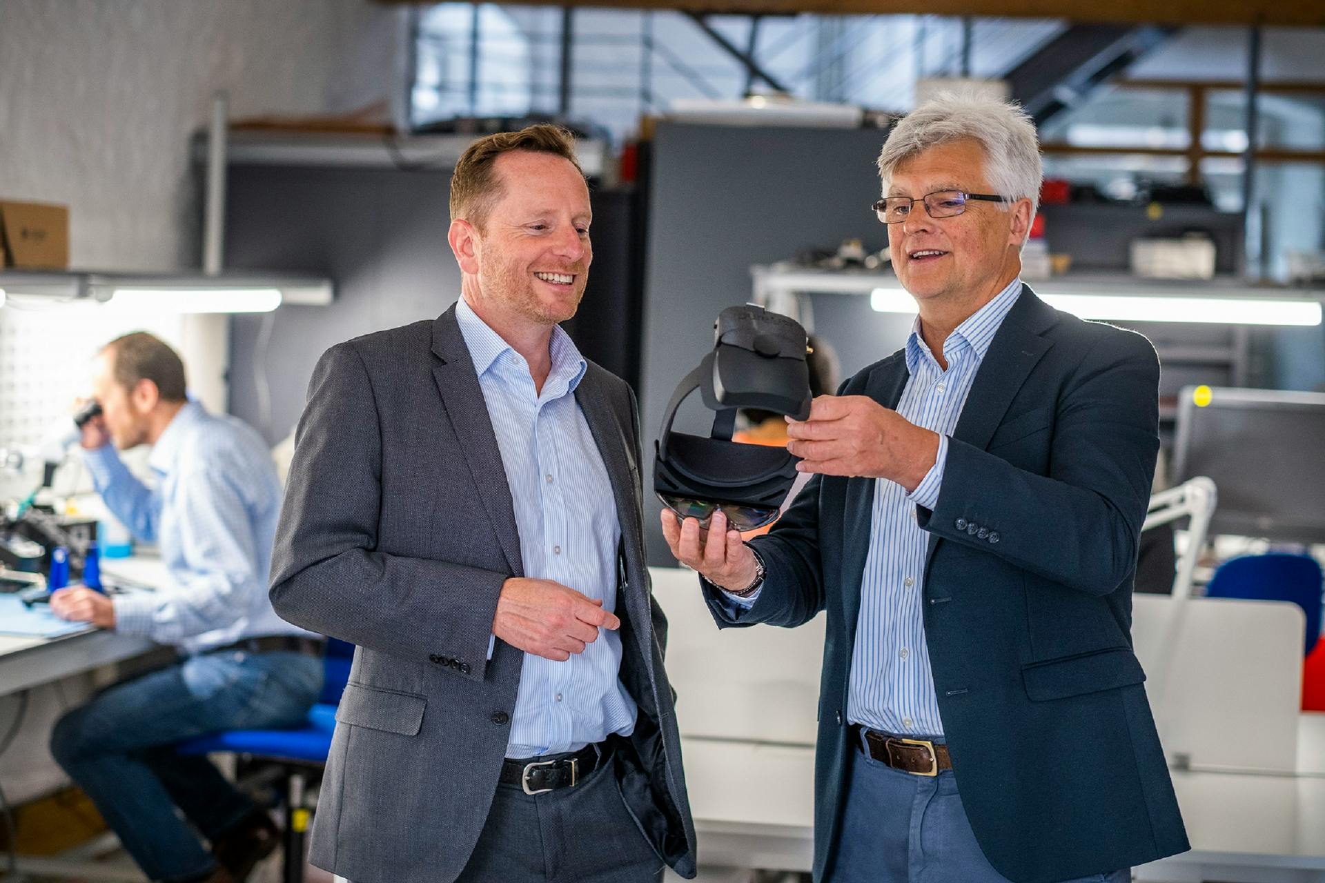 PureLiFi CEO Alistair Banham (right) and Scottish National Investment Bank executive director Jimmy Williamson admire a Li-Fi&ndash;enabled mixed reality headset &mdash; the Microsoft HoloLens &mdash; at pureLiFi&rsquo;s Edinburgh headquarters.