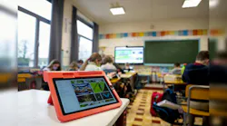 The tablet in the foreground would require a Li-Fi dongle to receive infrared signals traveling from transmitters attached to the ceiling luminaires in this classroom in Flobecq. (Photo credit: Both images courtesy of Signify.)