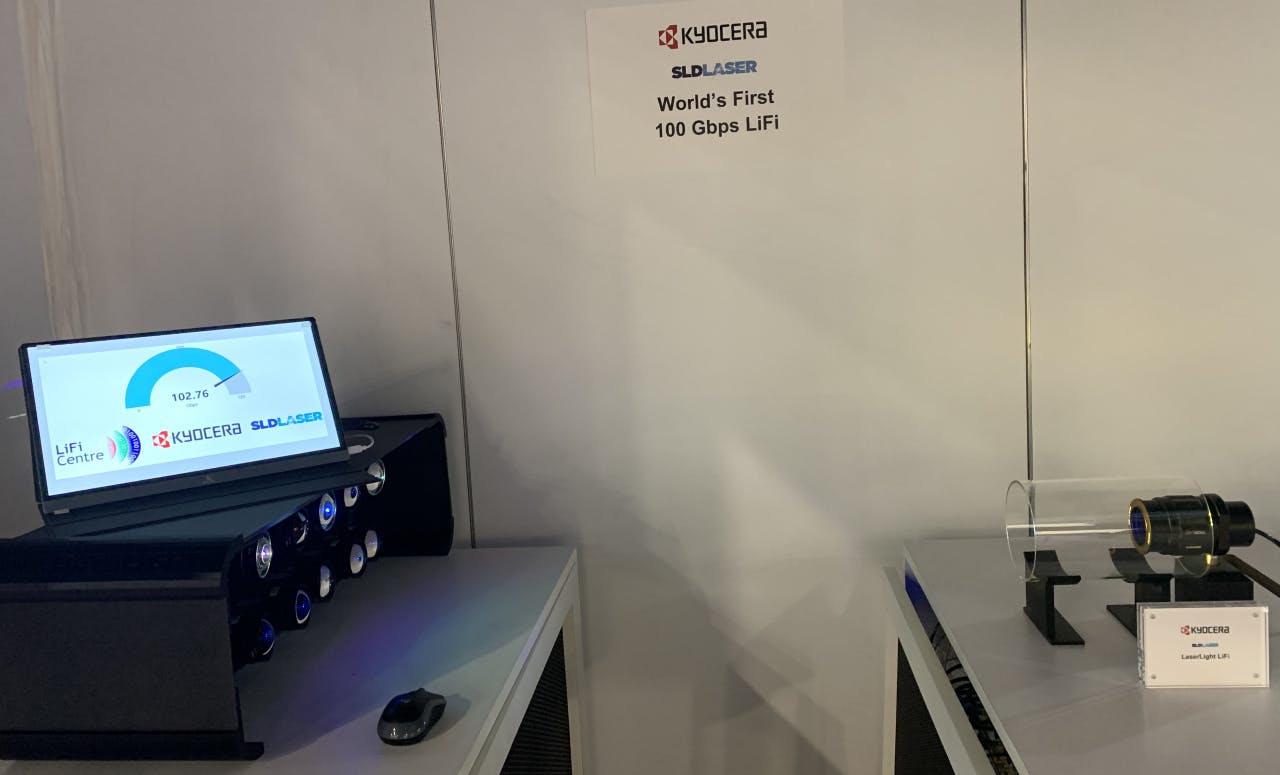 At the CES demo by Kyocera SLD Laser, 10 fibers fed the transmitter on the right with 7 different infrared wavelengths and 3 different blue wavelengths, each carrying data to the receiver on the left, where 10 different receivers were dedicated to one of the 10 wavelengths. The demo ran throughout the day at the company&rsquo;s booth. The speed was close to 103 Gbps at the moment the photo was taken. (Photo credit: Image courtesy of KSLD.)