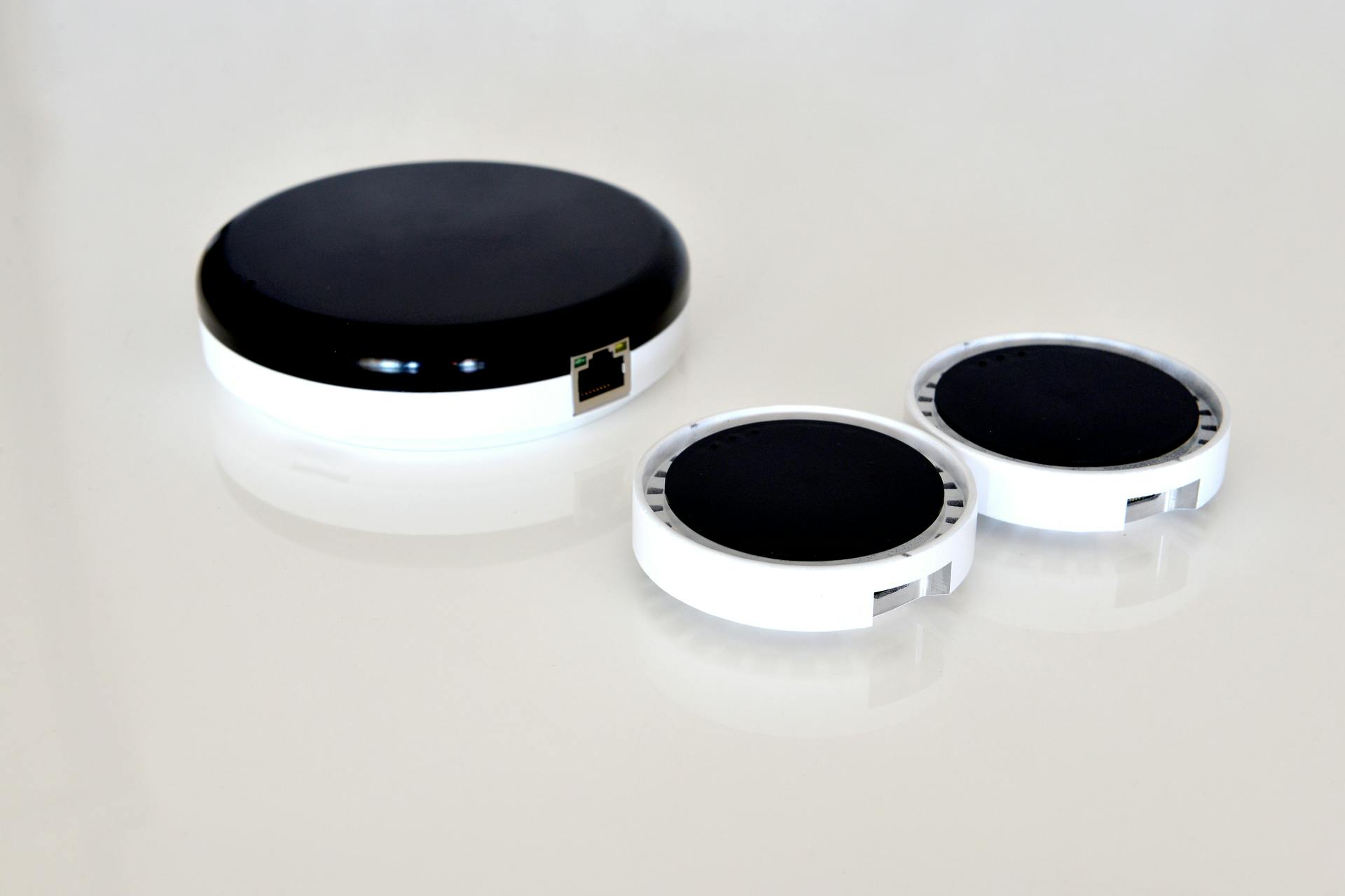 The larger of the three Oledcomm disks is the transmitter, designed to mount on a ceiling and attach to Ethernet cable. The smaller two are dongles, which attach to a laptop via USB cable, to deliver Li-Fi. (Photo credit: Image courtesy of Oledcomm.)