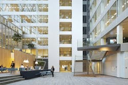 FIG. 1. The newly-built Edge building in Amsterdam is known for its IoT backbone and the ubiquitous deployment of Power over Ethernet as a backbone that enables advanced applications such as space optimization, but building retrofits need the flexibility of a wireless network and a standard intra-luminaire bus can enable flexible choices in inter-luminaire connectivity. (Photo credit: Image courtesy of Deloitte Group, photographer Ronald Tilleman; http://tilleman.nl.) FIG. 1. The newly-built Edge building in Amsterdam is known for its IoT backbone and the ubiquitous deployment of Power over Ethernet as a backbone that enables advanced applications such as space optimization, but building retrofits need the flexibility of a wireless network and a standard intra-luminaire bus can enable flexible choices in inter-luminaire connectivity. (Photo credit: Image courtesy of Deloitte Group, photographer Ronald Tilleman; http://tilleman.nl.)