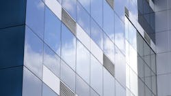 Exterior of modern glass building with ventilation grates. Exterior of modern glass building with ventilation grates.