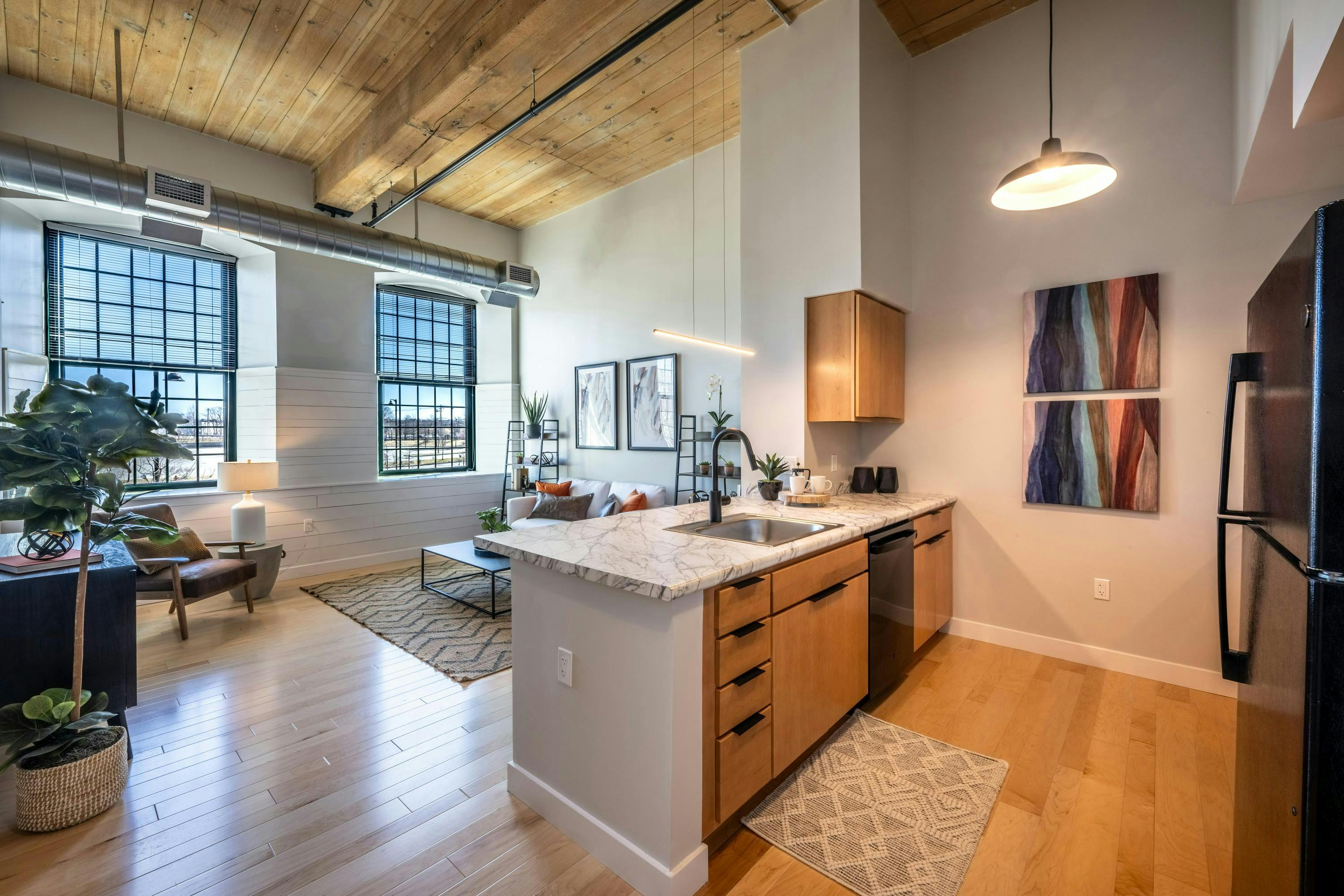 Renovated loft space with wood floors, modern kitchen, and restored historic windows.