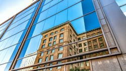 Reflection of old brick building in glass of new modern building. Reflection of old brick building in glass of new modern building.