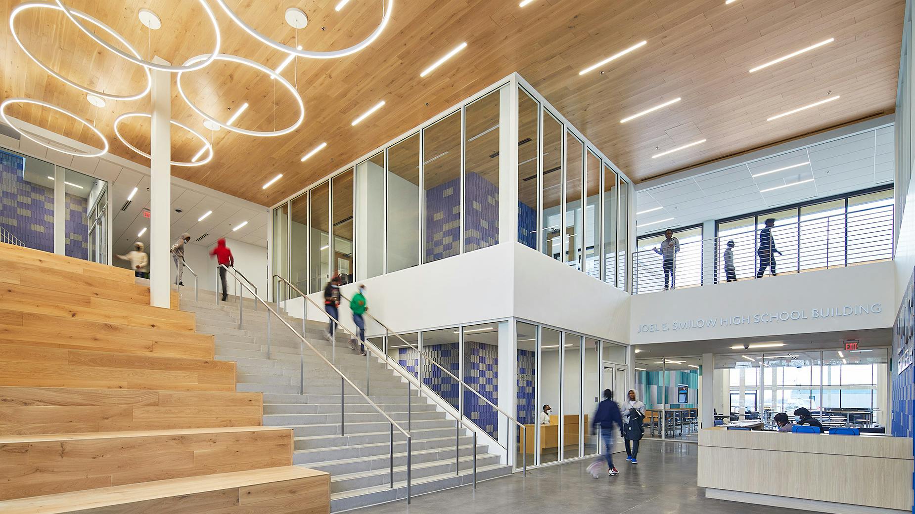 Blue and gray acoustic tiles on the walls at KIPP DC Legacy College Preparatory High School add color and warmth to the hard finishes used in the design and help reduce noise.
