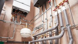 Hot water boiler room equipment with pipes mounted to wall. Hot water boiler room equipment with pipes mounted to wall.