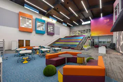 The library exemplifies the vivid color palette, such as the sunset mural, assembly stairs, and flexible furniture.