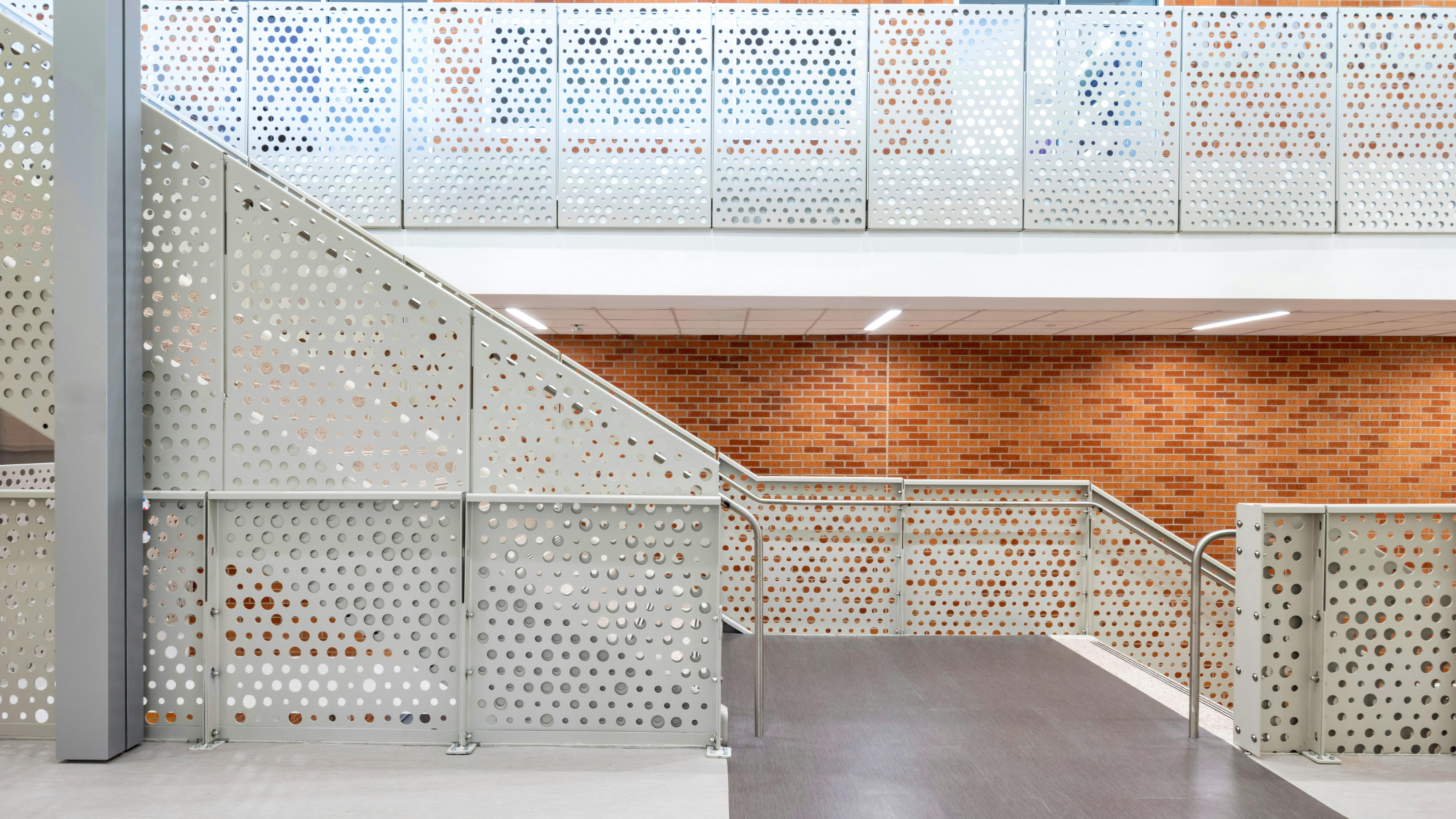 Arlington High School in Arlington, Texas, renovated its campus. A custom Stair Guardrail Fascia Mount with the B47 circular pattern delivers durable, code-compliant protection in a high-traffic educational environment.