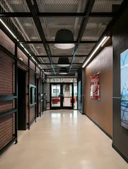 A leather-wrapped wall featuring a Rawlings patch greets people exiting the elevators. It’s framed by a custom steel cage and brick tile that help set the tone for the workspace. A leather-wrapped wall featuring a Rawlings patch greets people exiting the elevators. It’s framed by a custom steel cage and brick tile that help set the tone for the workspace.