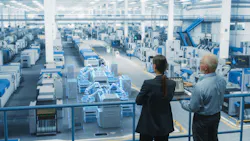 Courtesy gorodenkoff | Getty Images Man and woman stand above modern manufacturing facility floor with laptop in hand.