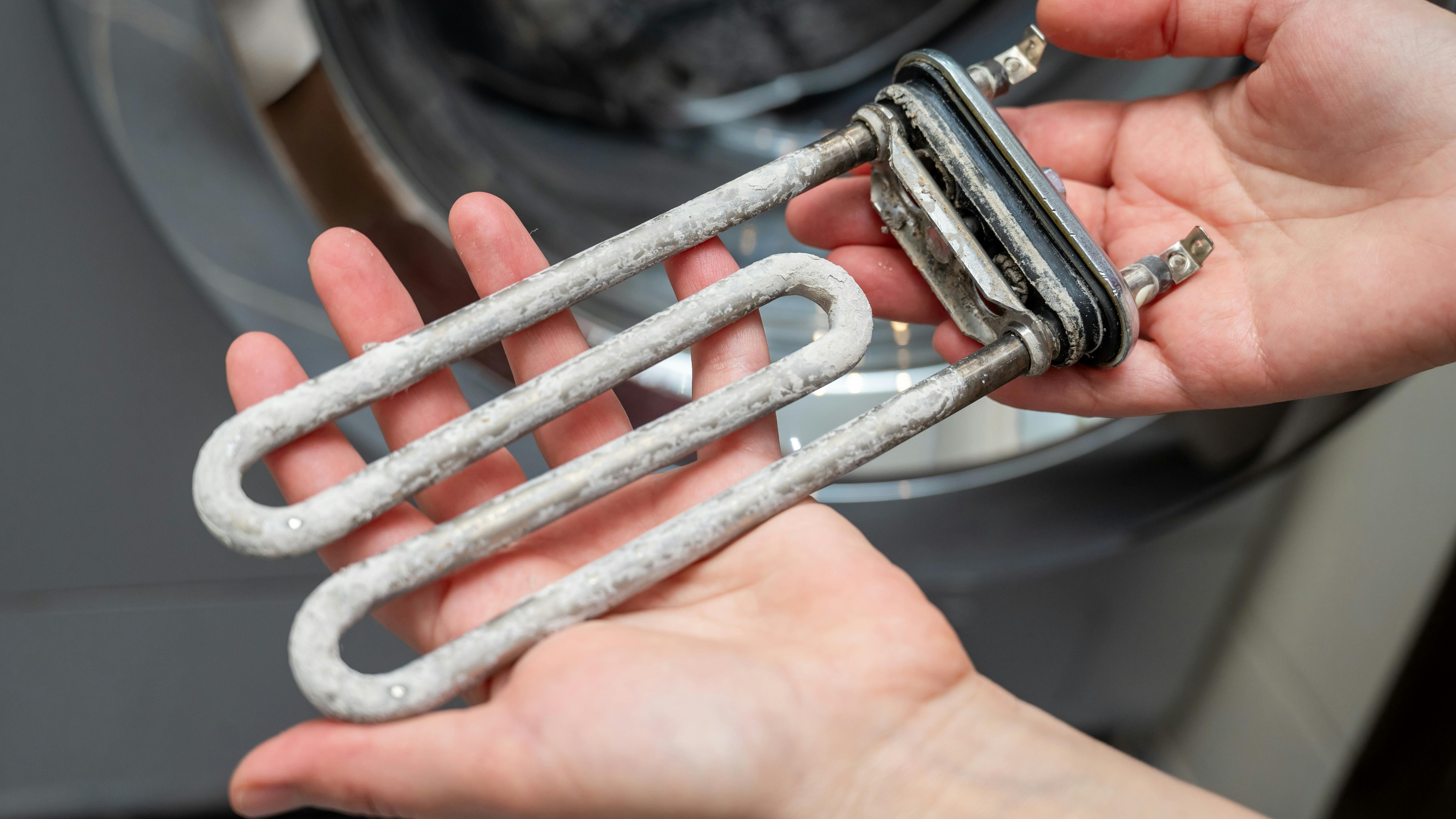 This washing machine heating element is covered in limescale.